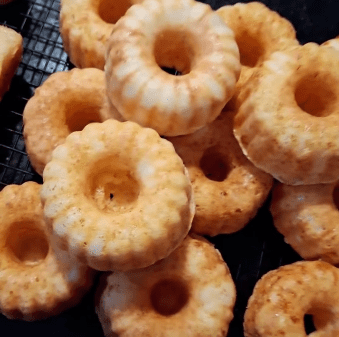 Bandeja com seis unidades de Mangulinos da Alecrim, mini bolos artesanais de pão de queijo feitos com Queijo Minas Artesanal. Os bolinhos dourados e fofinhos são apresentados como uma opção de lanche afetivo e tradicional de Minas Gerais para o café da manhã ou brunch em Belo Horizonte.