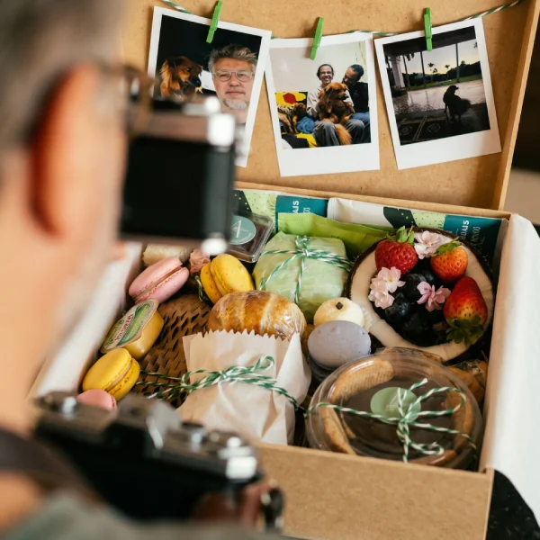 Detalhe de itens gourmet da cesta de café da manhã premium Alecrim. A foto destaca macarons artesanais, frutas vermelhas frescas e pães delicados organizados com olhar estético. Este nível de curadoria gastronômica em BH é pensado para anfitriões e presenteadores que valorizam o sabor autoral e a beleza em cada detalhe.