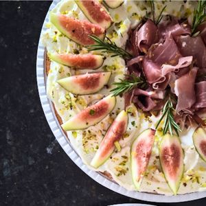 Guirlanda salgada da Alecrim com base de massa artesanal, cobertura de cream cheese, figos frescos e presunto cru tipo parma