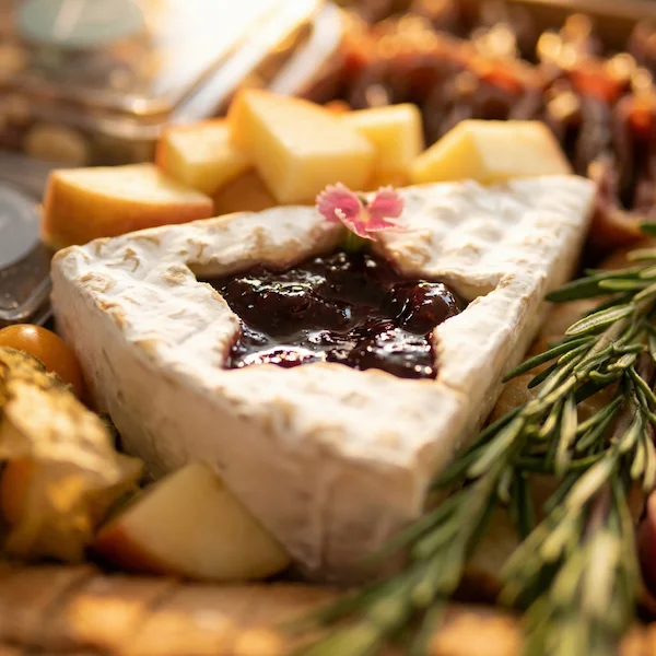 Tábua de frios de luxo, composta por charcutaria selecionada, queijos finos, torradas, pesto, castanha, morango e uvas.