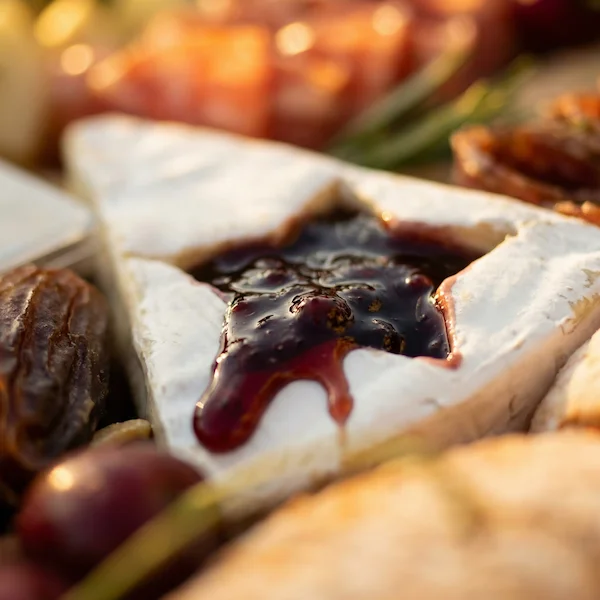 Tábua de frios de luxo, composta por charcutaria selecionada, queijos finos, torradas, pesto, castanha, morango e uvas.