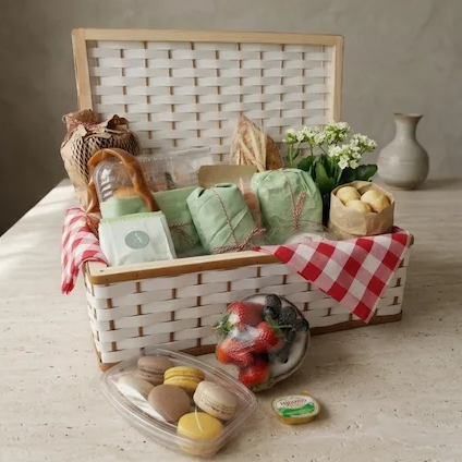 cesta de café da manhã tamanho família, contendo pães artesanais, quitandas, flores e frutas;